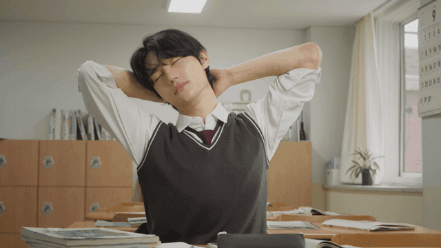 교실에서 공부하다가 스트레칭하는  학생