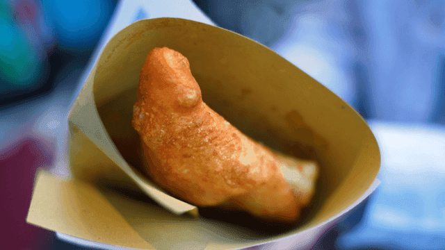 Crispy fried pizza frita in paper packaging