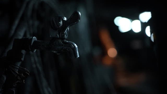 어두운 광산 내부의 수도꼭지에서 물이 떨어지는 장면