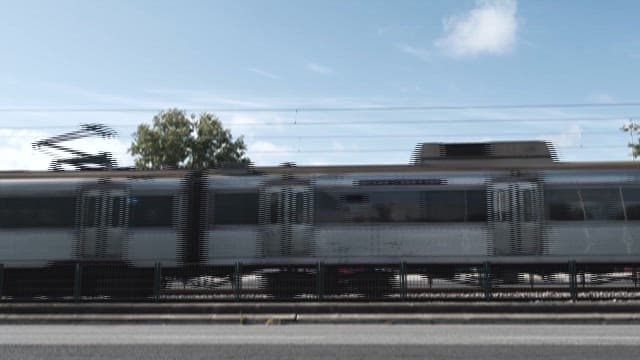 맑은 날 기차가 도시의 벽화길을 지나가는 모습