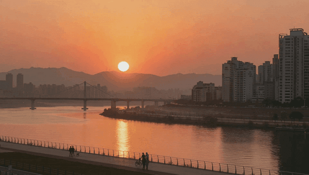 Sunset over a river with city skyline