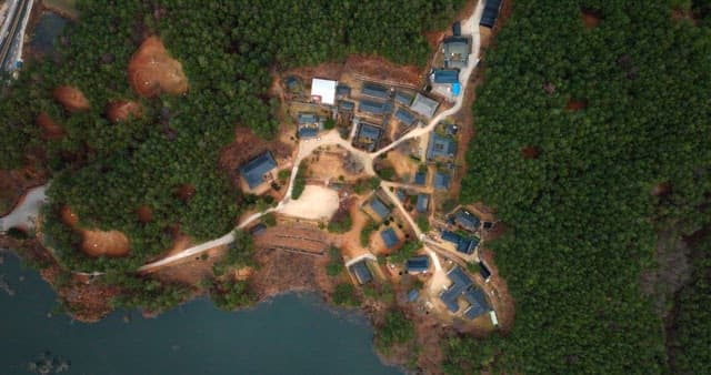 Aerial View of Traditional Village Surrounded by Forest
