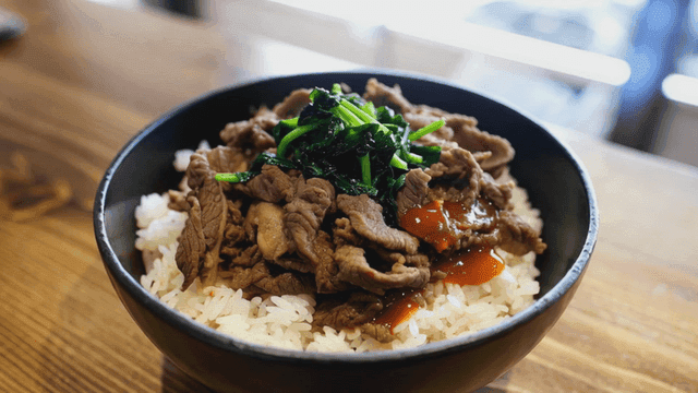 Bowl of rice topped with beef and vegetables