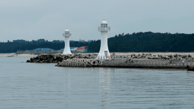 잔잔한 바다 옆 두 개의 하얀 등대