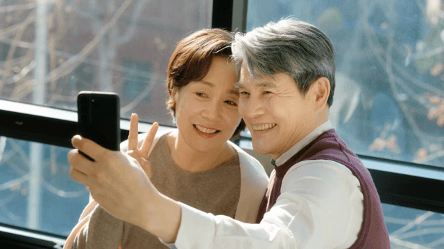 Elderly couple taking a selfie by the window