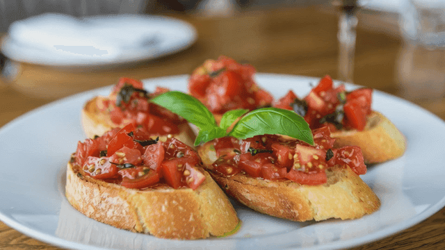 Bruschetta topped with plenty of tomatoes on toasted baguette