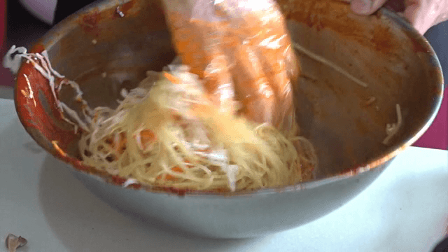 그릇에서 매운 소스와 면을 섞는 장면