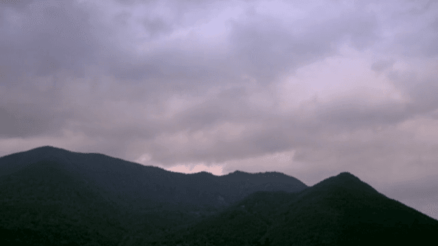 Pink clouds in the sky passing over the mountain