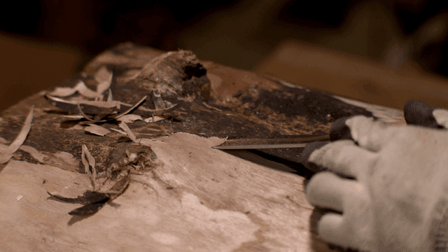 끌로 나무 표면을 조각하는 장인의 손