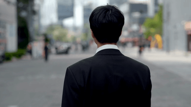 Man in office looks back and smiles while walking down the street