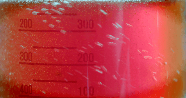 점점 섞이며 거품을 일으키는 플라스크 안 혼합되는 붉은 용액