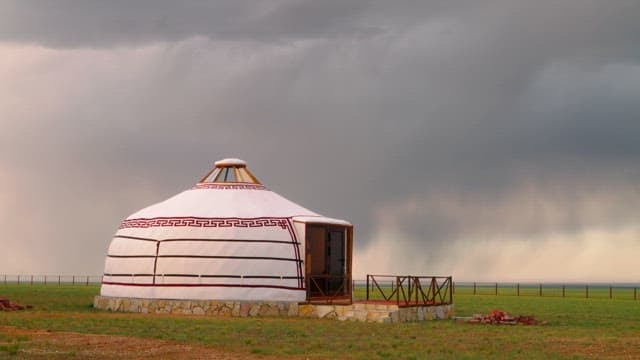 Yurt on a vast plain under cloudy skies