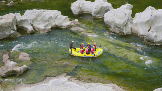 바위가 많은 강에서 래프팅을 즐기는 사람들