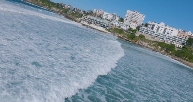 Coastal Cityscape with Waves Crashing Ashore