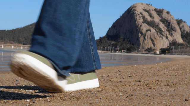 Feet walking on sandy beach
