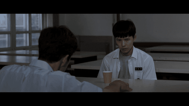 음료를 마시며 진지하게 대화 중인 학생과 교사