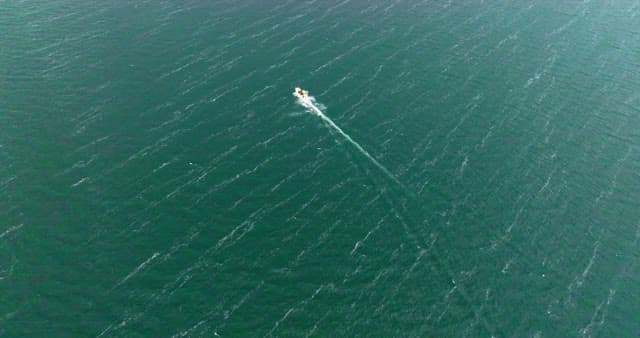 Boat sailing across a vast ocean