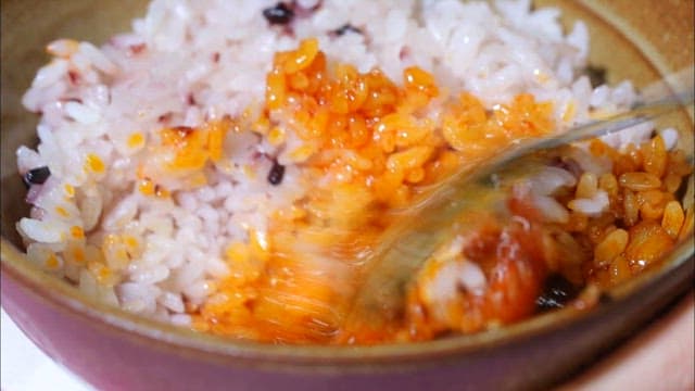 Braised pork ribs mixed with seasoning and rice in a bowl