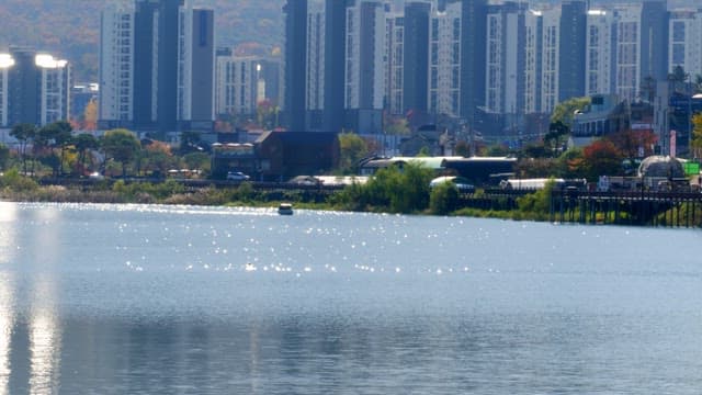 Calm Baegunhosu Lake surrounded by buildings with small boats floating around