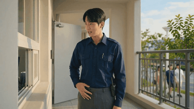 Young security guard in uniform handing over card