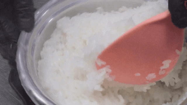 Stirring freshly cooked rice in a pot