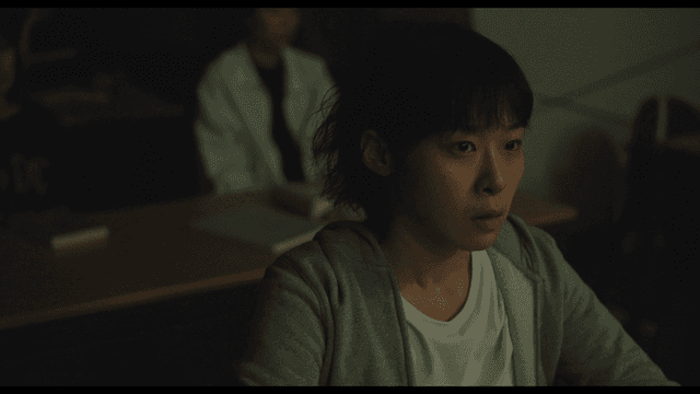 어두운 교실에서 집중하는 학생