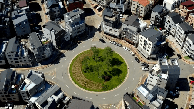 주택으로 둘러싸인 로터리의 항공 뷰