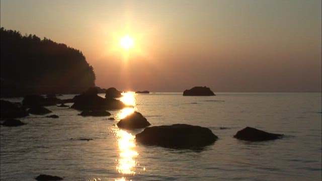 Serene Sunset at a Rocky Beach