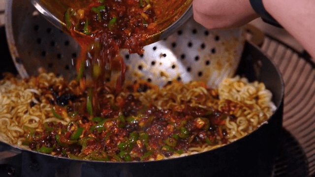매운 소스를 면 위에 붓는 장면