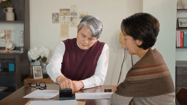 책상 위 서류를 읽고 도장을 찍는 남성