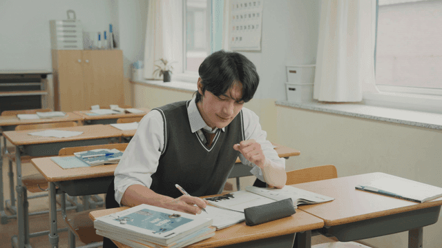 홀로 남아 교실에서 공부하다 하품하고 스트레칭하는 학생