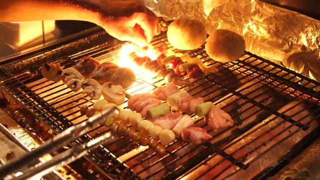 그릴 위에서 먹음직스럽게 구워지는 꼬치들