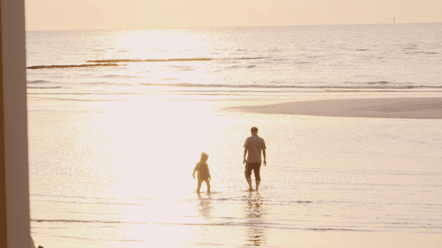 해변을 걷는 아버지와 아이