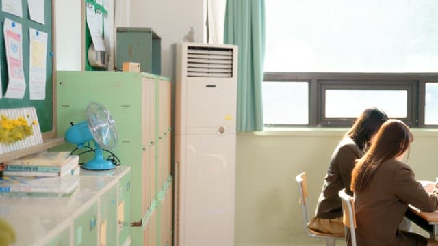 사물함에 가방을 넣고 친구들과 잡담하는 학생