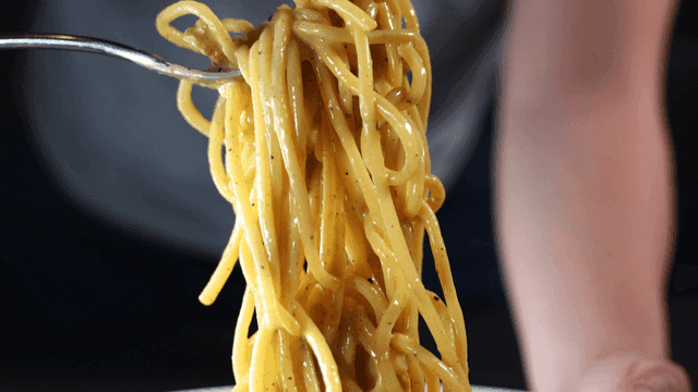 Creamy pasta lifted with fork