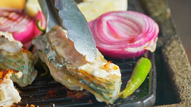 Grilling juicy parrotfish on an outdoor barbecue grill