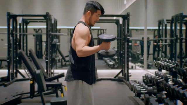 헬스장에서 덤벨을 드는 남성