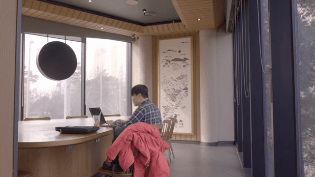 카페에서 노트북으로 작업하는 사람