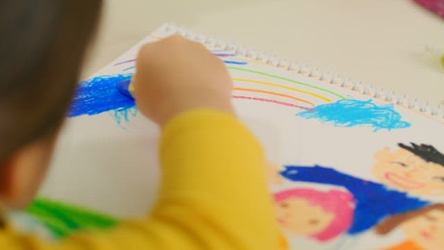 Child Coloring a Picture with Crayons