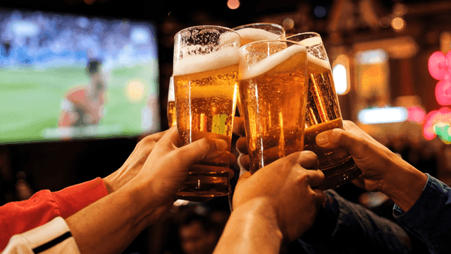 Friends toasting with beer in a bar