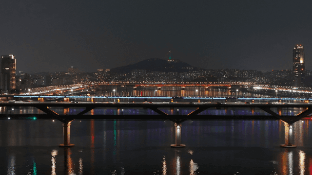 Cars driving on river against city backdrop