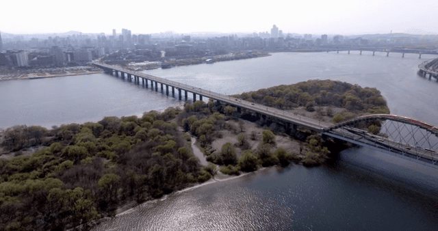 A bridge over a river with a city skyline