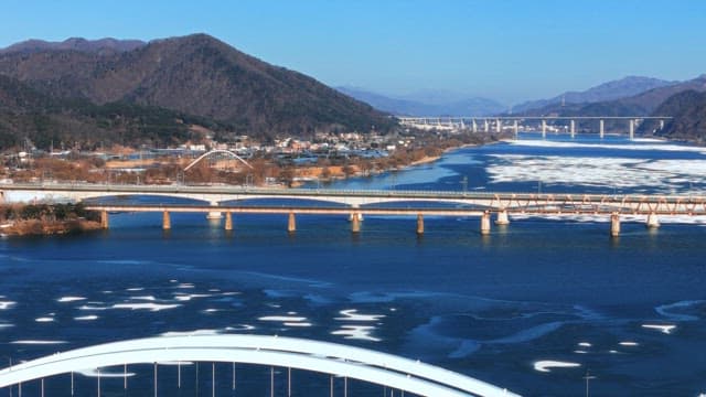 Frozen River with Multiple Bridges and Mountains