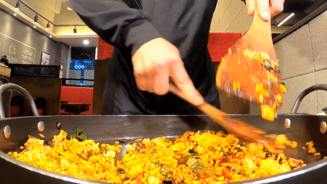 철판에서 빠르고 정확하게 볶음밥을 만드는 요리사