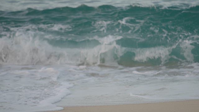 Waves Crashing onto a Serene Sandy Beach