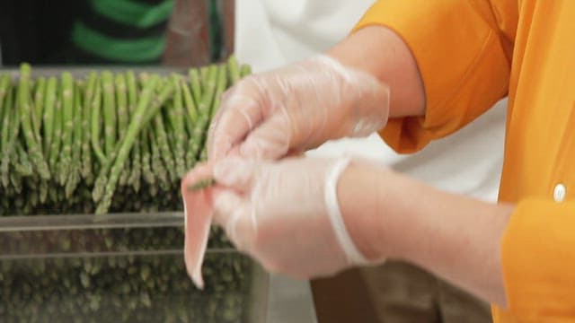 주방에서 대패삼겹살에 아스파라거스를 마는 모습