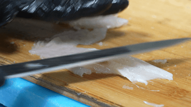 Fresh pufferfish sashimi being sliced ​​on cutting board