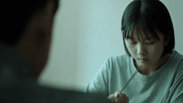 우울한 표정으로 식탁에서 밥을 먹는 소녀