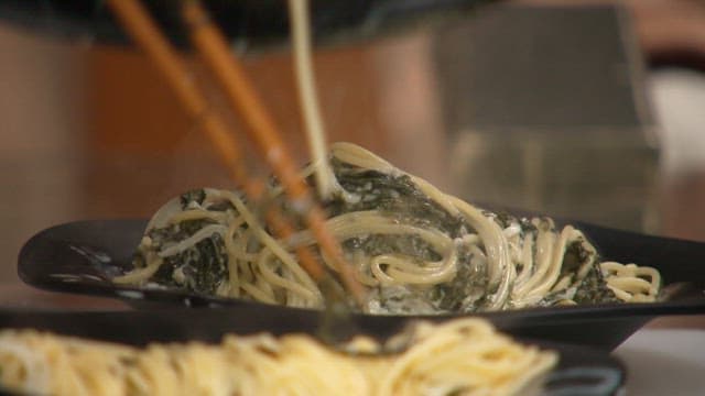 Pouring creamy sauce on hot pasta