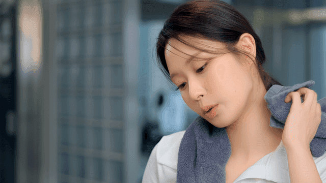 헬스장에서 수건으로 땀을 닦는 젊은 여성